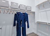 Thumbnail 8 of 23 - Two blue robes hanging on a rack in a room.