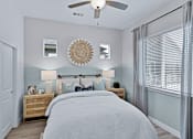 Thumbnail 7 of 23 - A bedroom with a bed, nightstands, and a ceiling fan.