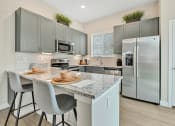 Thumbnail 7 of 14 - an open kitchen with stainless steel appliances and a marble counter top at Avilla Towne Center Apartments, Texas