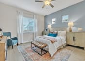 Thumbnail 4 of 14 - a bedroom with a bed and a ceiling fan at Avilla Towne Center Apartments, Texas