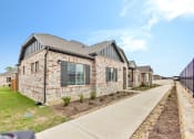 Thumbnail 3 of 14 - an exterior view of a brick house with a sidewalk and grass at Avilla Towne Center Apartments, Texas, 75407