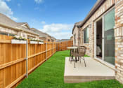 Thumbnail 5 of 14 - a backyard patio with a table and chairs and a fence at Avilla Towne Center Apartments, Texas, 75407