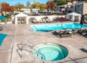 Thumbnail 12 of 32 - a swimming pool with chairs and umbrellas at an apartment complex