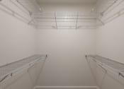 Thumbnail 30 of 32 - the walk in closet in a white room with two empty shelves