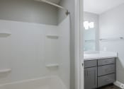 Thumbnail 32 of 32 - a bathroom with a shower and a sink and a mirror
