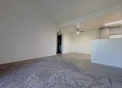 Thumbnail 27 of 41 - an empty living room with white walls and a concrete floor at Sharlands Terrace Apartments, Reno, NV, 89523