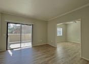 Thumbnail 18 of 41 - an empty living room with a sliding glass door to a balcony at Sharlands Terrace Apartments, Reno, 89523