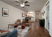Thumbnail 8 of 31 - the view of a living room with a ceiling fan and a kitchen at The Fountains Apartments, Florida, 32514