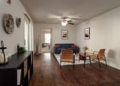 Thumbnail 7 of 31 - a living room with a couch and a table and a ceiling fan at The Fountains Apartments, Pensacola, Florida