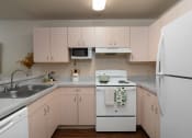 Thumbnail 9 of 31 - a kitchen with white appliances and white cabinets at The Fountains Apartments, Pensacola, FL