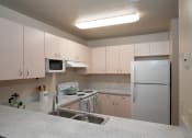 Thumbnail 12 of 31 - a kitchen with white cabinets and a sink and a refrigerator at The Fountains Apartments, Pensacola, 32514