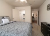 Thumbnail 20 of 31 - a bedroom with a large bed and a view of a bathroom and a closet at The Fountains Apartments, Pensacola, Florida