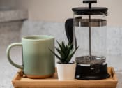 Thumbnail 16 of 31 - a coffee maker on a tray with a mug and a plant at The Fountains Apartments, Pensacola, Florida, 32514