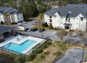 Thumbnail 4 of 31 - an aerial view of a swimming pool in front of an apartment building at The Fountains Apartments, Pensacola, FL