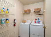 Thumbnail 14 of 31 - a laundry room with washer and dryer and a closet with shelves at The Fountains Apartments, Pensacola, FL