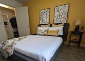 Thumbnail 22 of 31 - a bedroom with a bed and two paintings on the wall at Tivoli Apartments of Orlando, Oviedo, FL