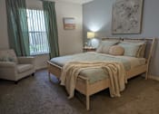 Thumbnail 25 of 31 - a bedroom with a bed and a chair and a window at Tivoli Apartments of Orlando, Oviedo, 32765
