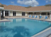 Thumbnail 13 of 31 - a large swimming pool in front of a building with a resort style pool at Tivoli Apartments of Orlando, Oviedo, Florida