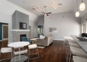 Thumbnail 9 of 39 - The clubhouse with a dining room and a kitchen with stools at Stoneridge Apartments, Gainesville, FL