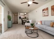 Thumbnail 30 of 39 - the living room and dining room of an apartment with a couch and a table at Stoneridge Apartments, Gainesville, Florida