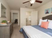 Thumbnail 33 of 39 - a bedroom with a bed and a dresser and a ceiling fan at Stoneridge Apartments, Gainesville, FL, 32608