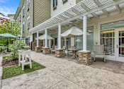 Thumbnail 41 of 50 - A patio with a table and chairs under a white pergola  of Spring Arbor of Severna Park