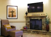 Thumbnail 8 of 8 - A living room with a fireplace and a television.