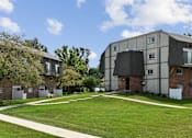 Thumbnail 32 of 35 - Apartment buildings with curved walkway and green lawn at Fox Run Apartments, Illinois