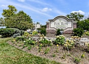 Thumbnail 18 of 35 - Monument sign with brick base and seasonal flowers at Fox Run Apartments, St. Charles, IL