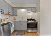 Thumbnail 3 of 28 - a kitchen with stainless steel appliances and blue cabinets at Aspen Ridge Apartments, West Chicago, IL
