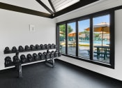 Thumbnail 17 of 28 - a fitness room with weights and a view of a pool at Aspen Ridge Apartments, West Chicago, IL, 60185