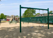 Thumbnail 24 of 28 - a playground with a swing set and monkey bars in a park at Aspen Ridge Apartments, West Chicago