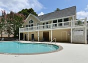 Thumbnail 29 of 35 - the pool is in front of a large house with a porch