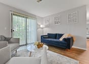 Thumbnail 16 of 35 - a living room with a blue couch and a glass coffee table