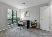 Thumbnail 12 of 35 - an office with a large window and a desk with a chair