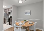Thumbnail 10 of 35 - a dining room with a table and chairs and a kitchen