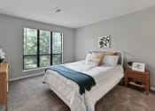 Thumbnail 15 of 35 - a bedroom with a bed and a large window