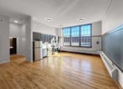 Thumbnail 3 of 24 - an empty living room and kitchen with wood floors and a window