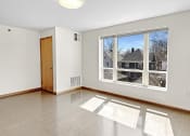 Thumbnail 8 of 52 - an empty living room with a large window and wooden floors