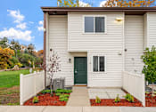 Thumbnail 8 of 23 - A house with a green door and a white fence.