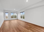 Thumbnail 15 of 36 - an empty living room with a wood floor and three windows