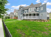 Thumbnail 24 of 27 - a house with a yard and a fence in front of it