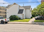 Thumbnail 53 of 67 - a white house on the corner of a street with a truck