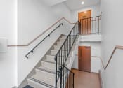 Thumbnail 22 of 27 - a staircase in a building with stairs and a door