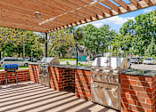 Thumbnail 5 of 55 - a patio with two barbecue grills and a wooden roof