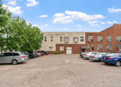 Thumbnail 26 of 31 - a large brick building with cars parked in front of it