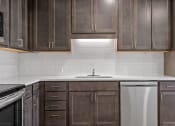 Thumbnail 16 of 45 - an empty kitchen with wooden cabinets and a white counter top