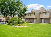 Thumbnail 29 of 41 - the view of an apartment building with a yard and grass