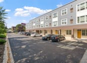 Thumbnail 28 of 52 - a large apartment building with cars parked in front of it