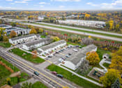 Thumbnail 23 of 23 - A road with cars and a white building with a grey roof.